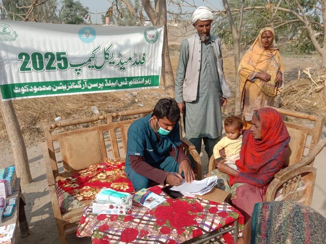 DPO doctor screening an elderly woman holding a baby at Flood Medical Camp 2025