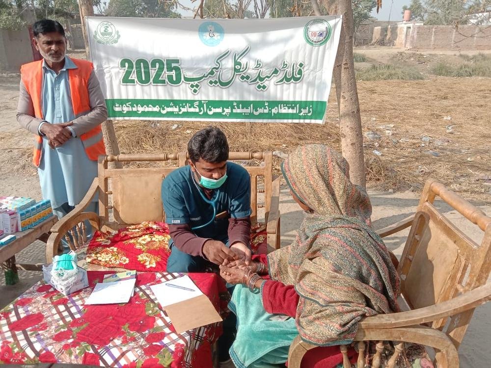 Doctor checking an elderly woman at a DPO medical camp